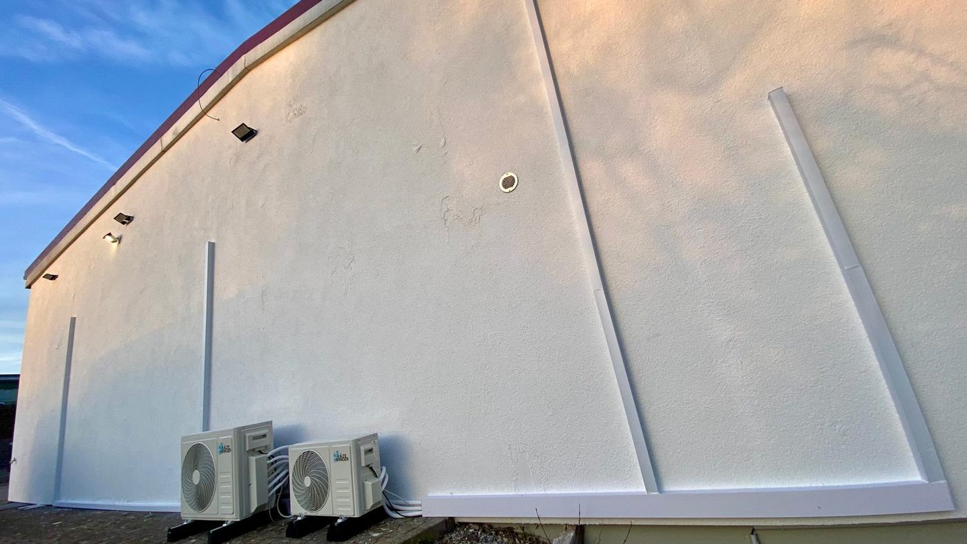 Zwei Außeneinheiten an einer Gewerbefassade in der Abendsonne